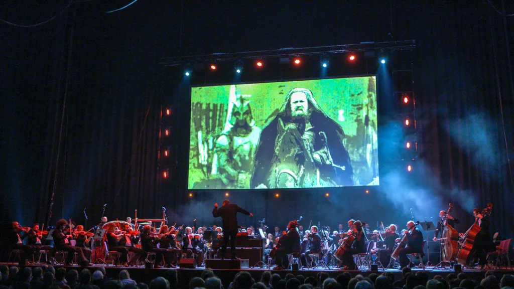 Teaserbild zu Game Of Thrones & House Of The Dragon mit Orchester und Projektion auf großer Leinwand.