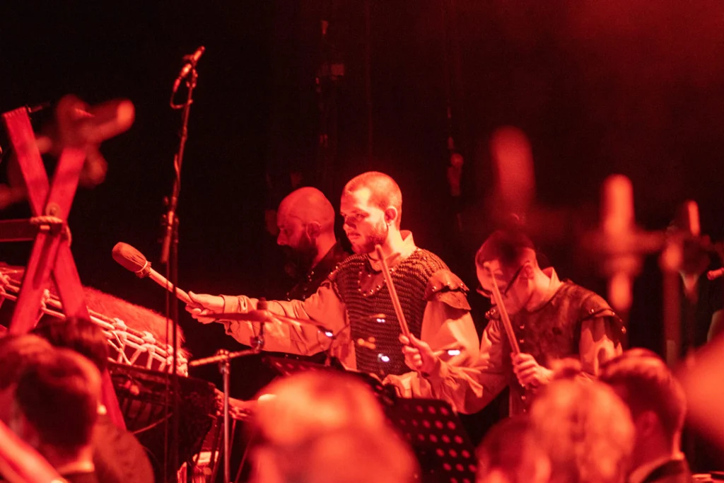 Musiker in historischen Kostümen spielen auf der Bühne bei einem Konzert.
