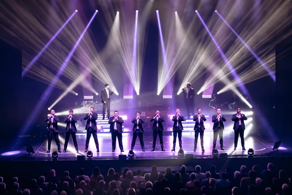Auftritt der 12 Tenors auf der Bühne mit Lichtern und Publikum.