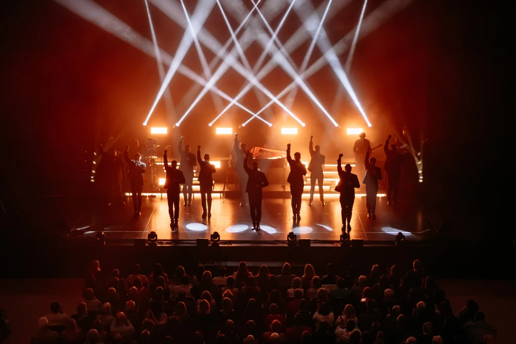 Teaserbild zu The 12 Tenors mit einer Bühnenaufführung und Lichtern.