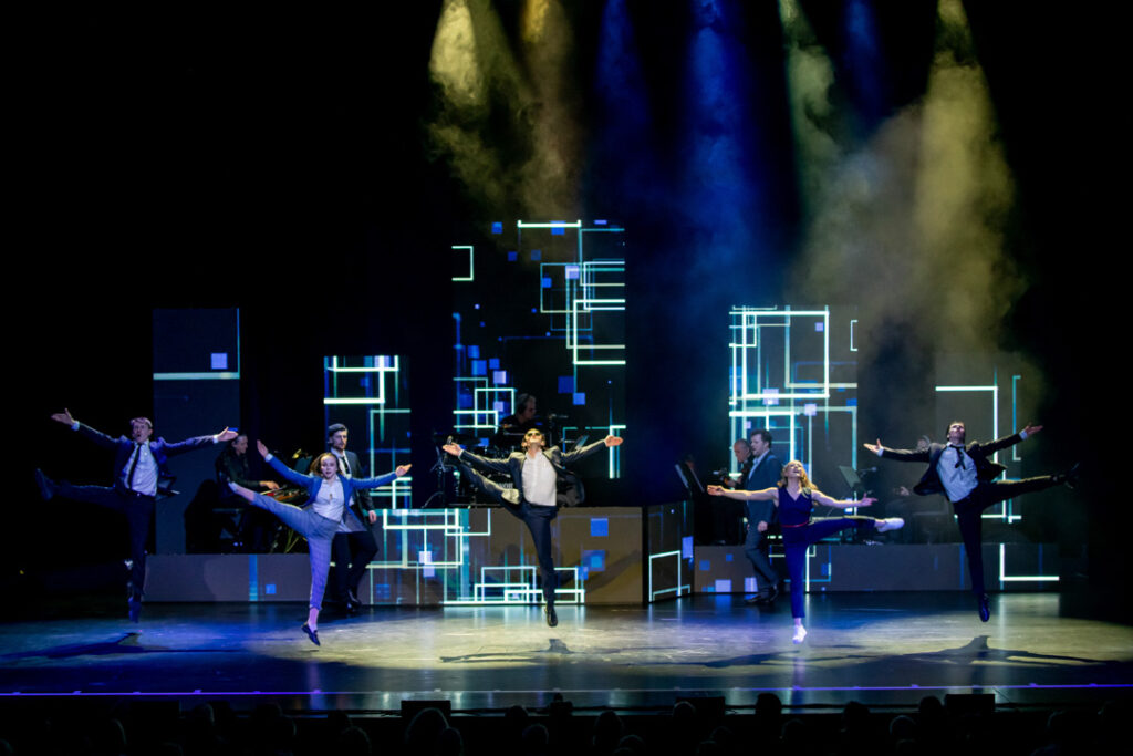 Tanzaufführung aus dem Musical Chess mit mehreren Tänzern auf der Bühne.