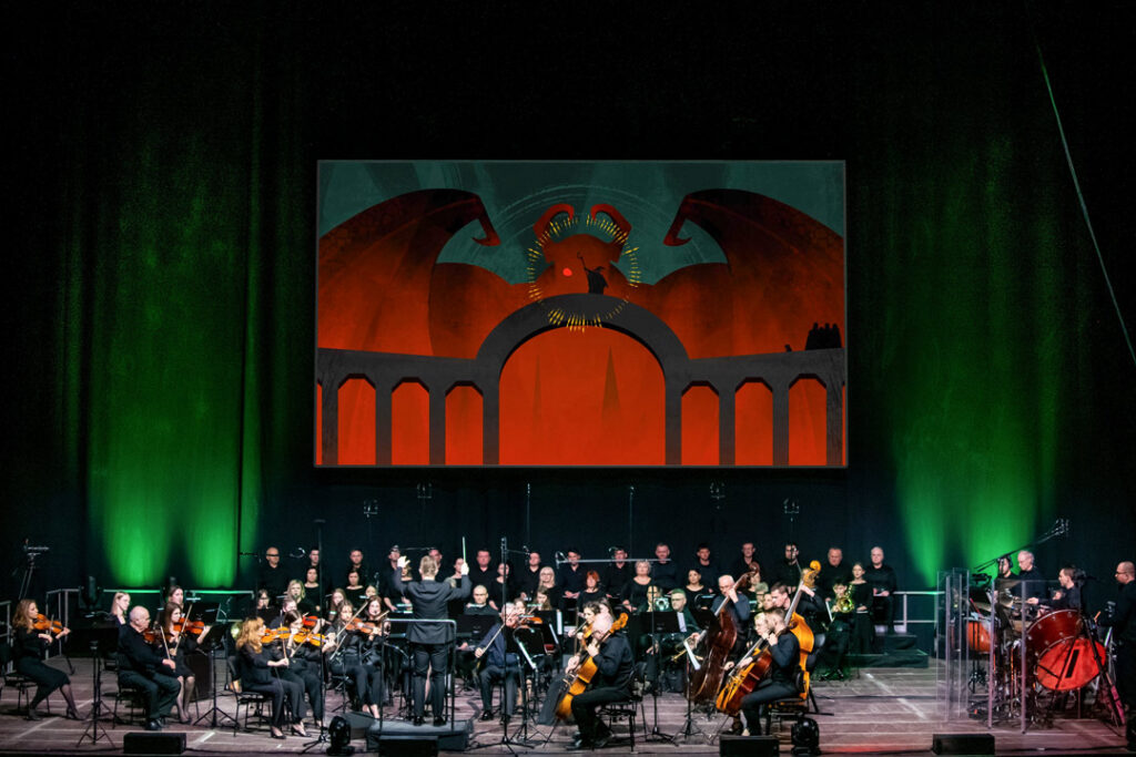 Teaserbild zu Der Herr der Ringe mit Orchester und dramatischer Bühnenkulisse.