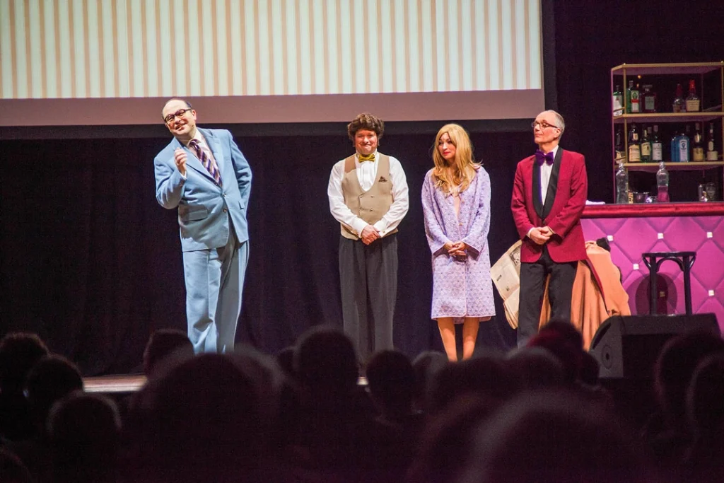 Szenenbild aus der 'Die Neue Heinz Erhardt Revue' mit vier Darstellern auf der Bühne.