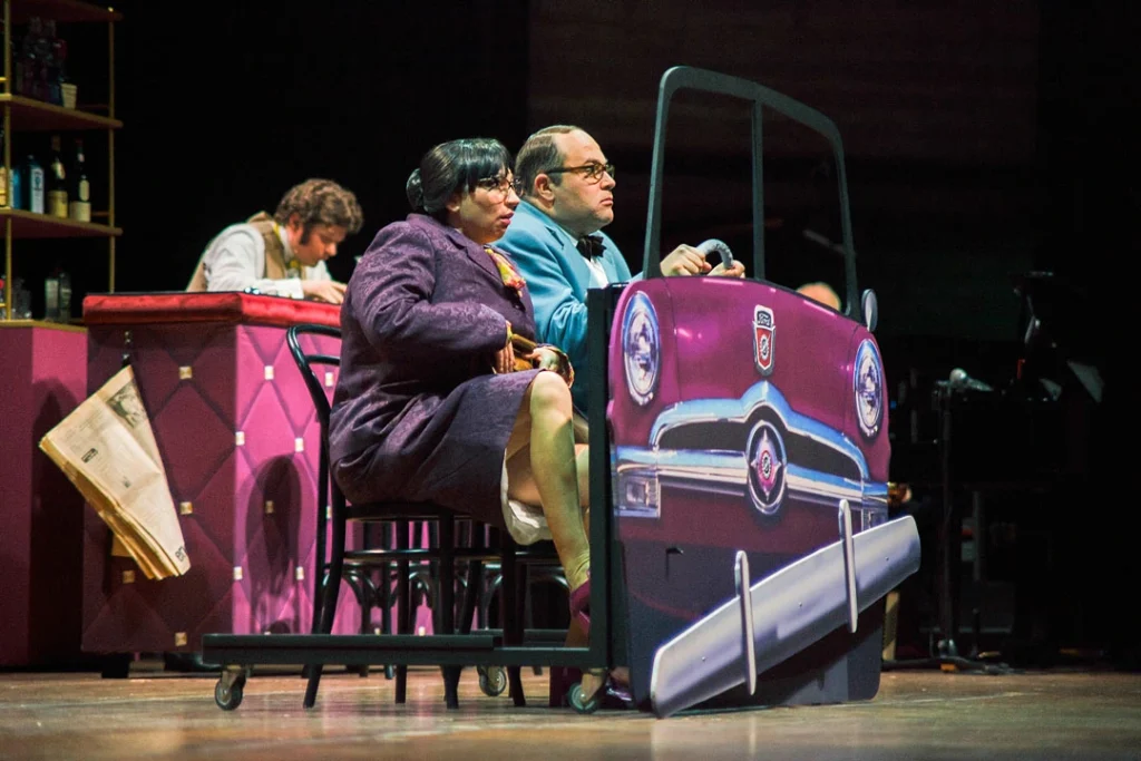 Szenenbild aus der 'Heinz Erhardt Revue' mit zwei Schauspielern in einem Auto.