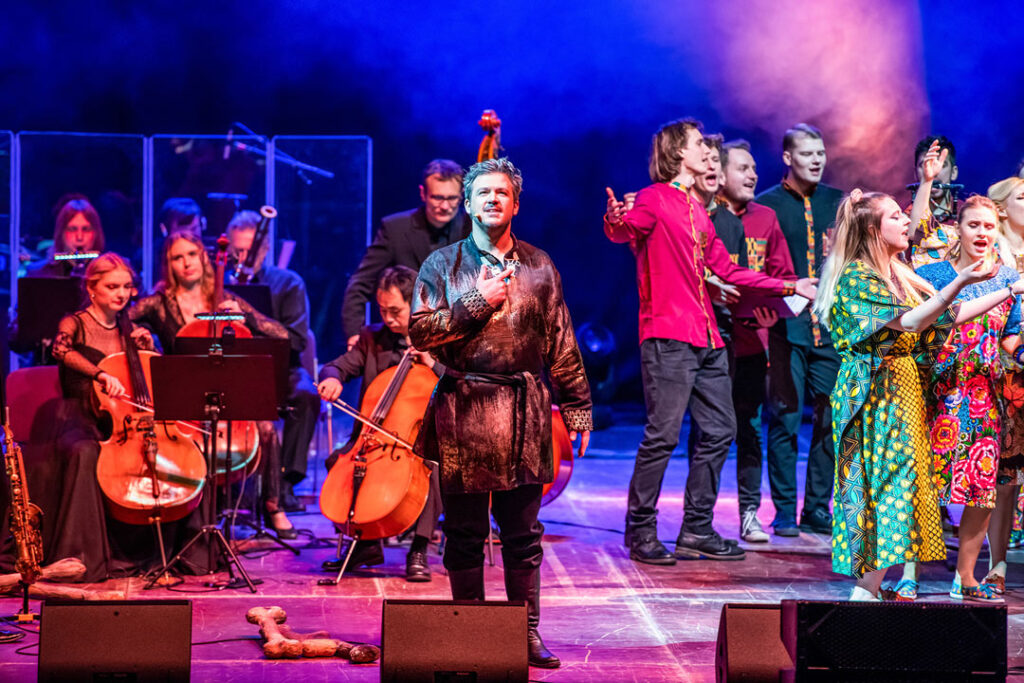 Theateraufführung von Der König der Löwen mit Darstellern in bunten Kostümen auf der Bühne.