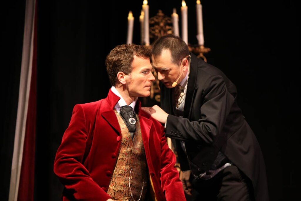 Szenenbild aus Das Phantom der Oper mit zwei Darstellern in historischen Kostümen.