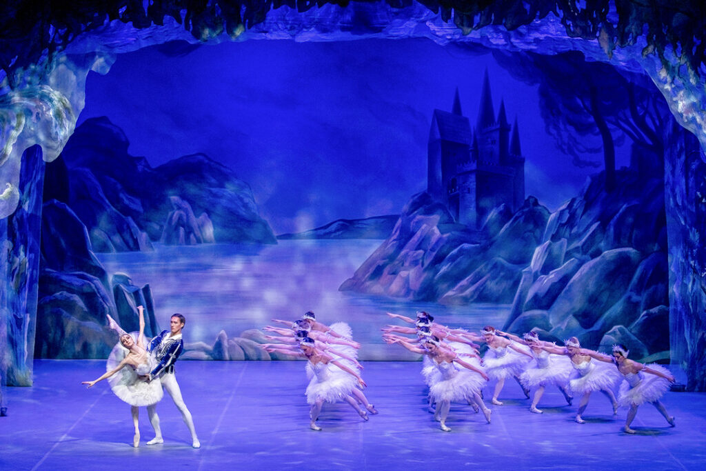 Teaserbild zu Schwanensee mit tanzenden Balletttänzern auf einer Bühne.