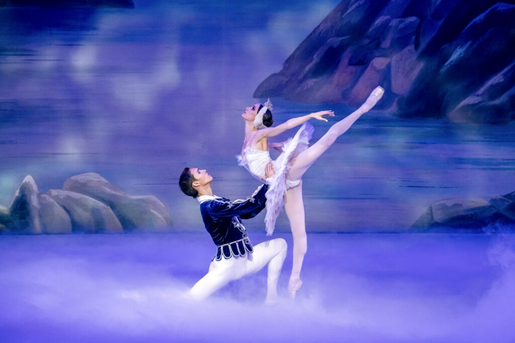 Teaserbild zu Schwanensee mit tanzenden Balletttänzern auf einer Nebelbühne.