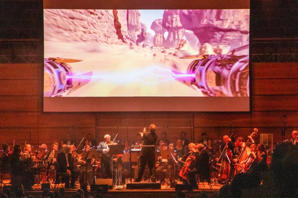 Teaserbild zu The Music of Star Wars mit Orchester und Projektion einer Szene aus Star Wars.