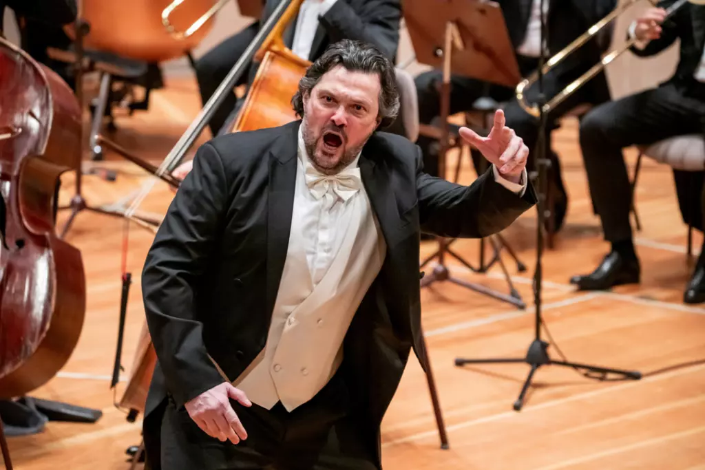 Sänger bei der Verdi Gala auf der Bühne, umgeben von einem Orchester.