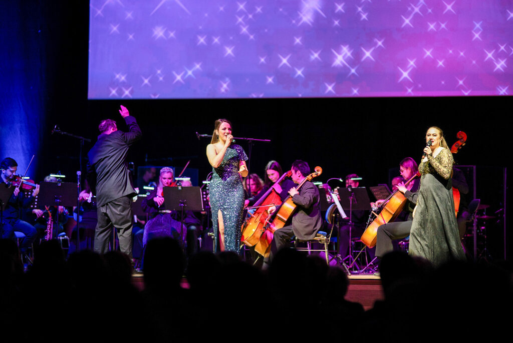 Teaserbild zu Highlights der schönsten Musicals mit Sängern und Orchester auf der Bühne.