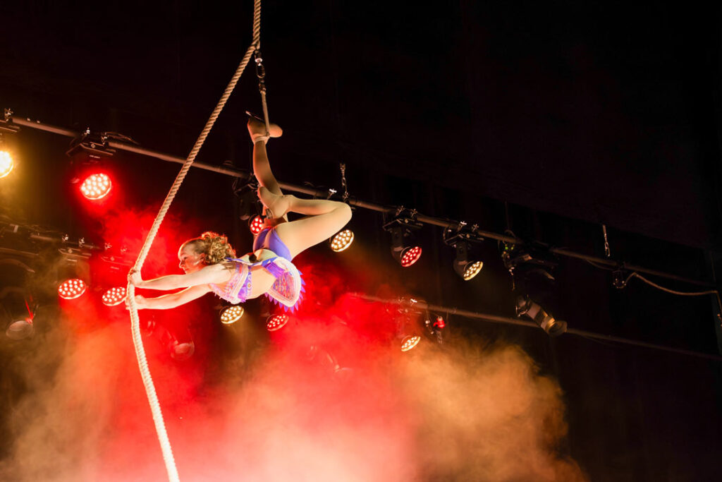 Teaserbild zu Musical Dreams mit einer Artistin, die an einem Seil schwingt.